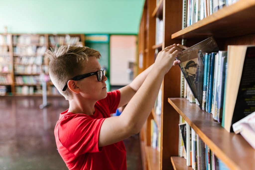 A child browsing through a library shelf