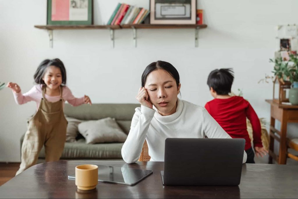 Momkids Working women on laptop and children are playing in background