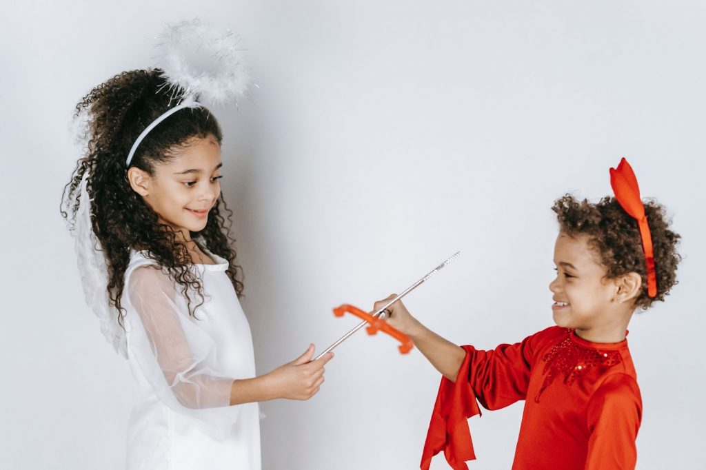 Kids pretending to be angel and devil