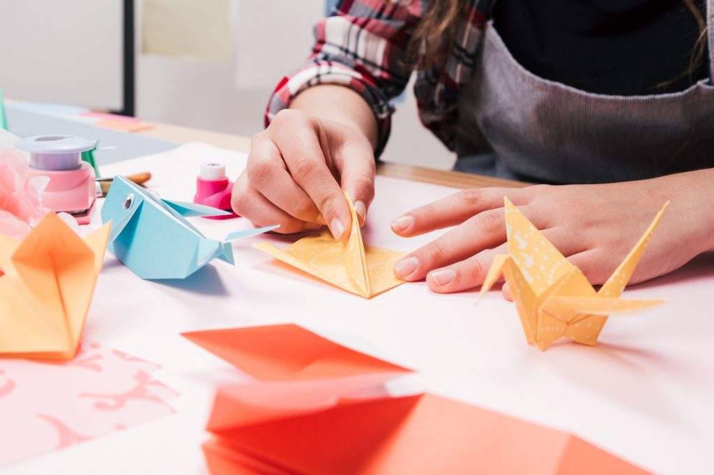 A woman making creative craft art from origami paper