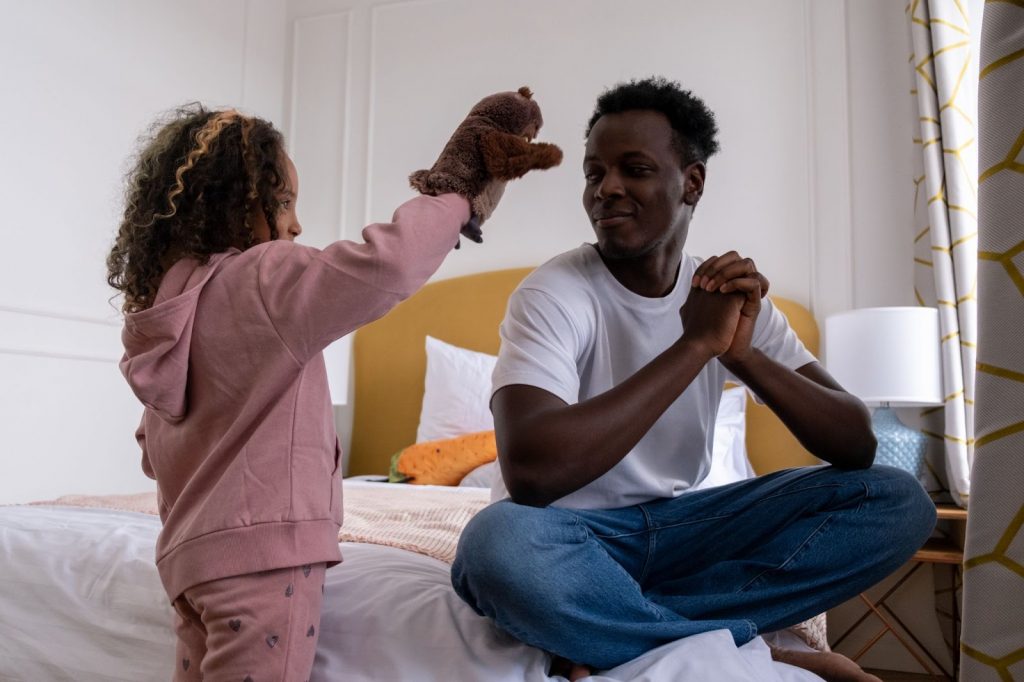 Kid showing a puppet to her father