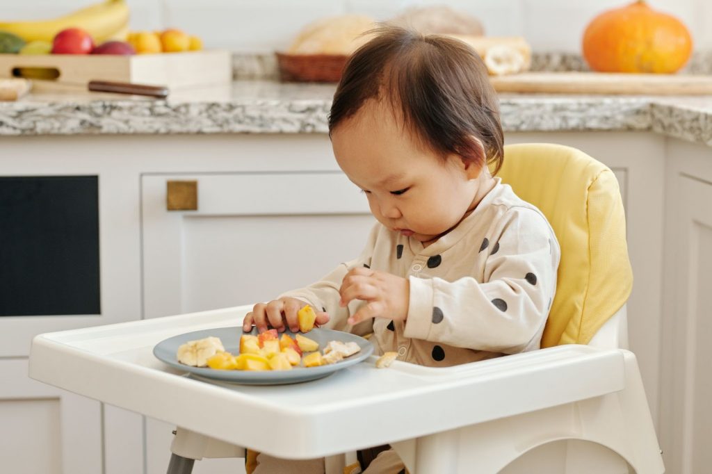 Baby eating diced pieces of an apple