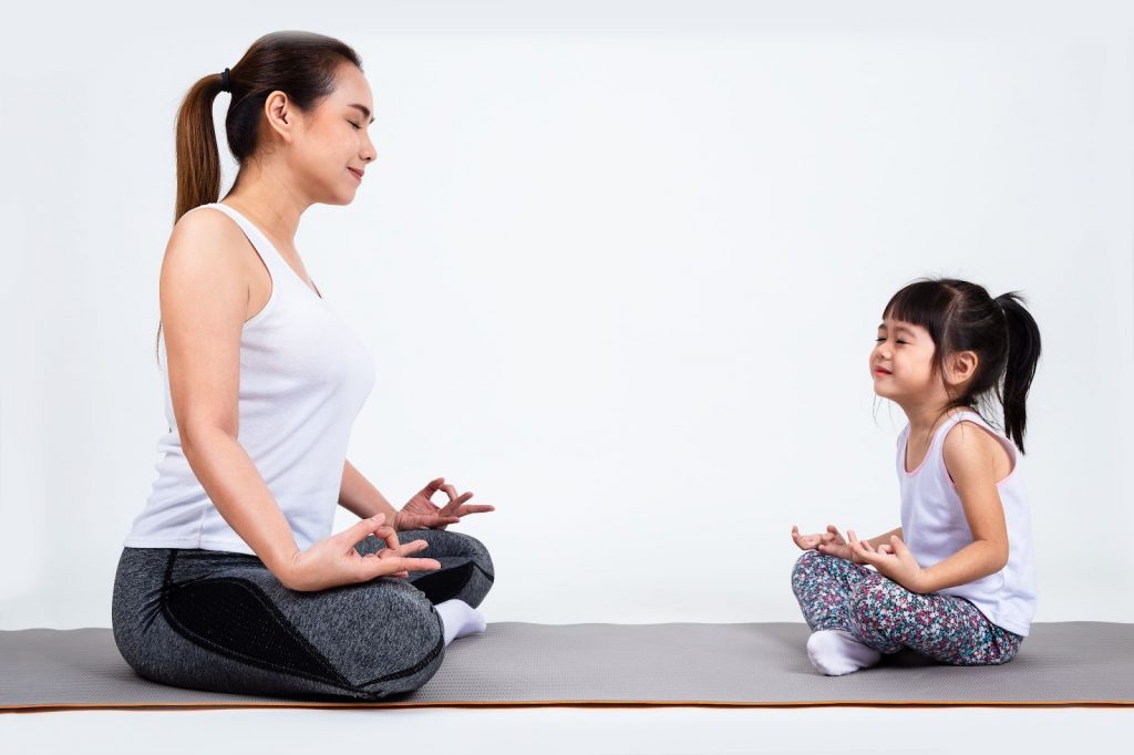 Mom and daughter meditating together