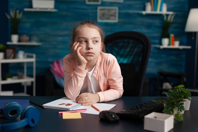 A girl sitting on chair looking worried