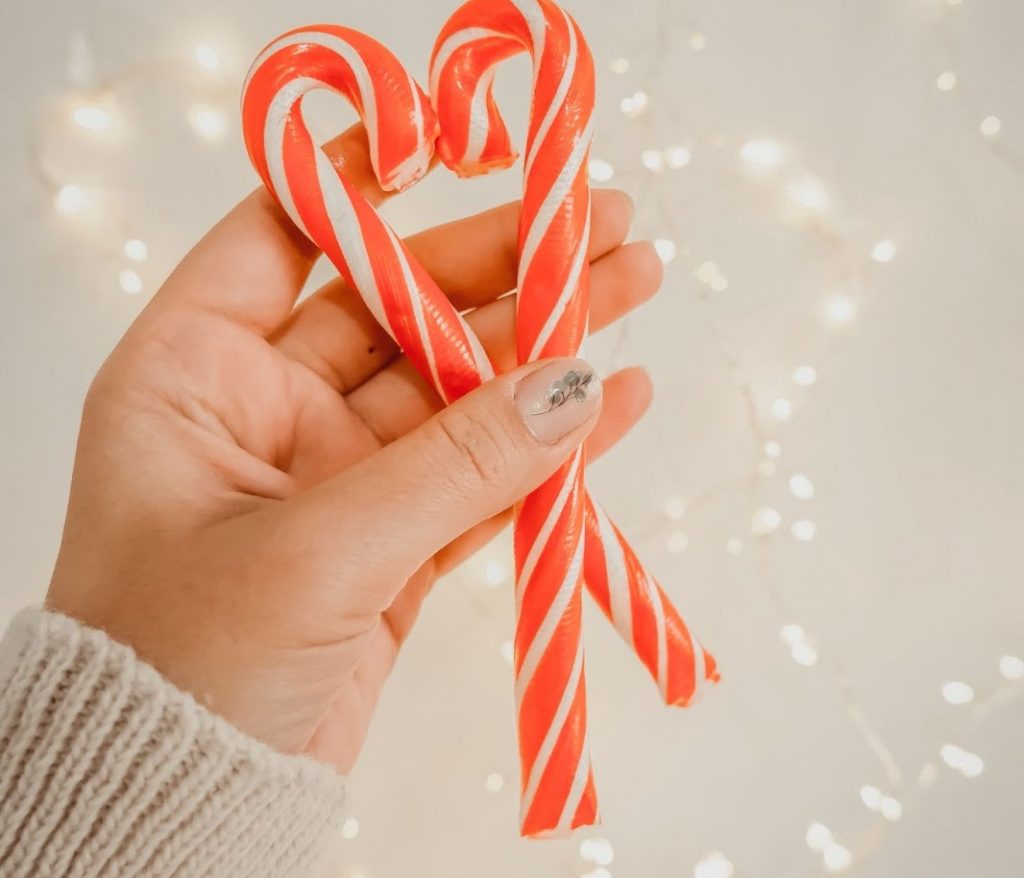 A person holding two candy canes together