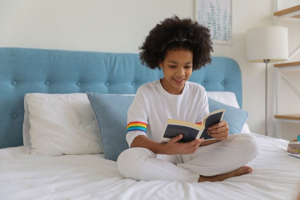 Girl reading a book on the bed