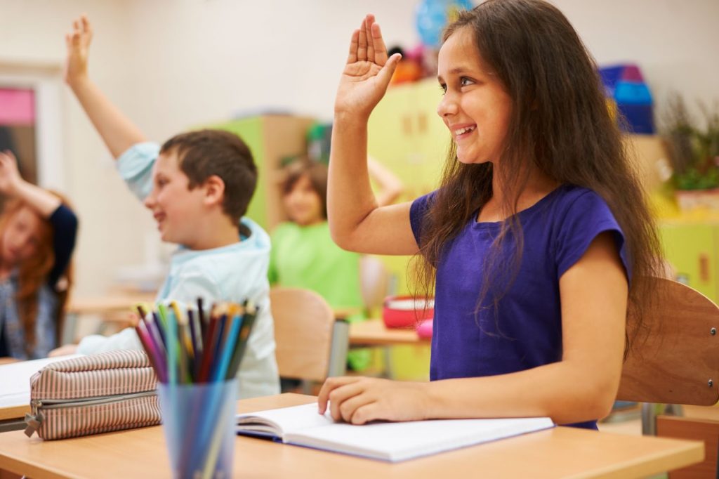 Kids raising hands in classroom