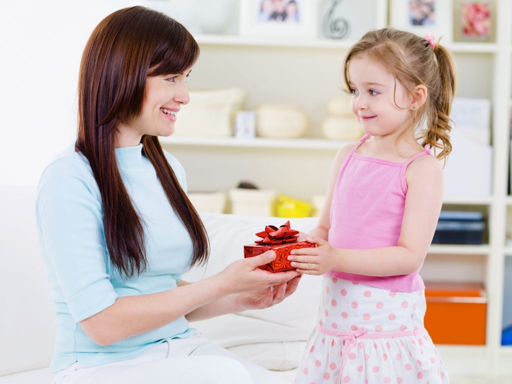 Mother handing out a gift to her daughter
