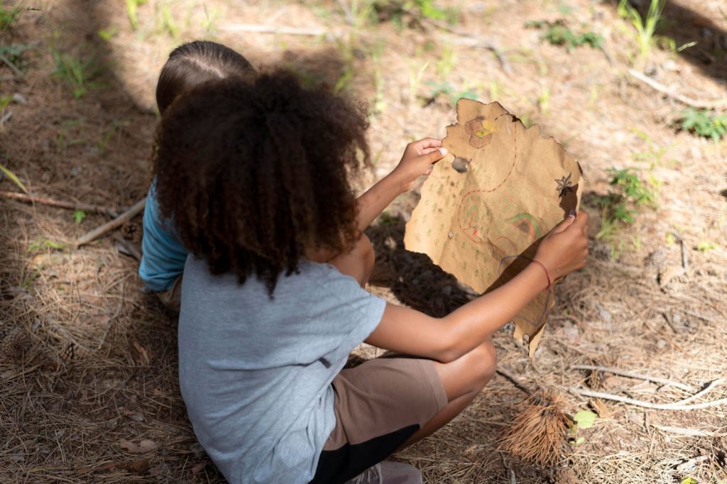 Two kids looking at a treasure hunt map