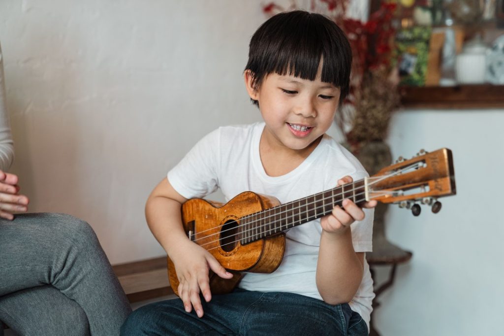 Happy boy playing ukulele