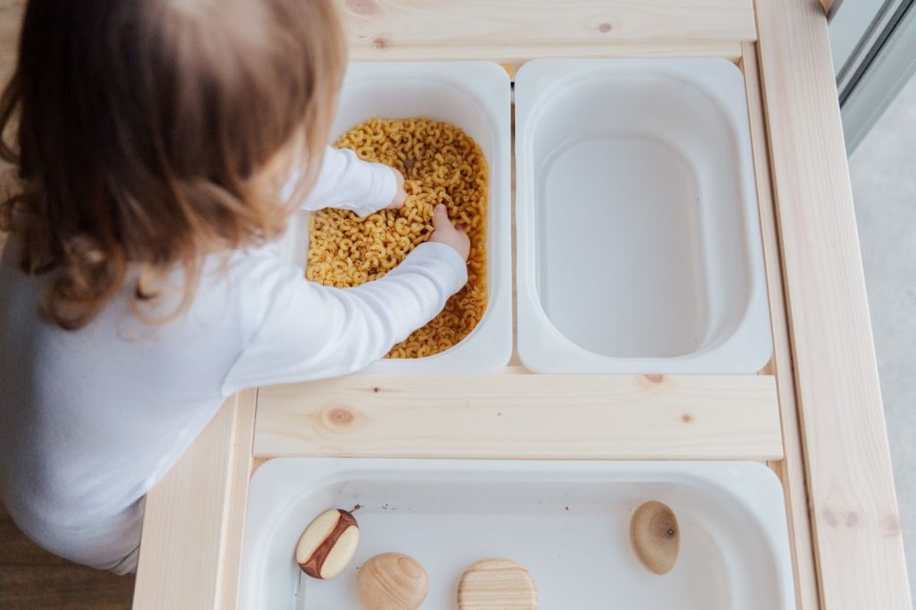 Child playing with pasta