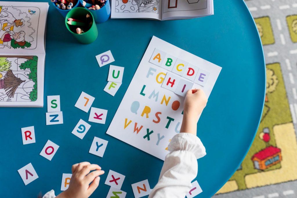 A kid putting letter stickers on a paper