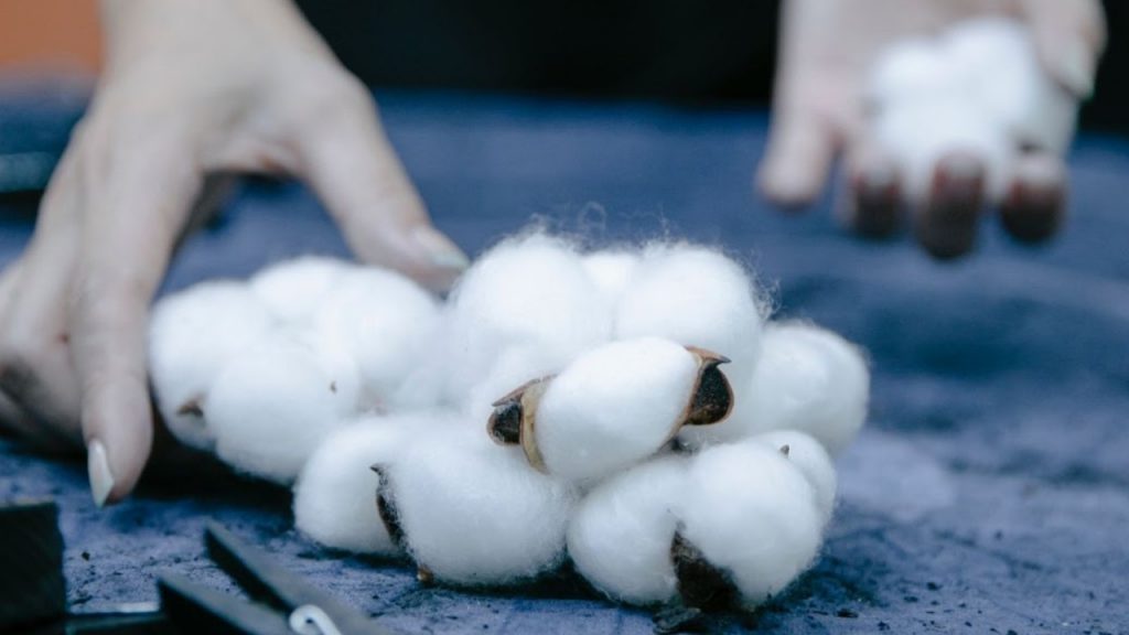 A hand reaching towards cotton balls