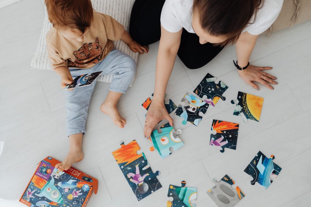 Top view of a woman playing puzzles with her kid