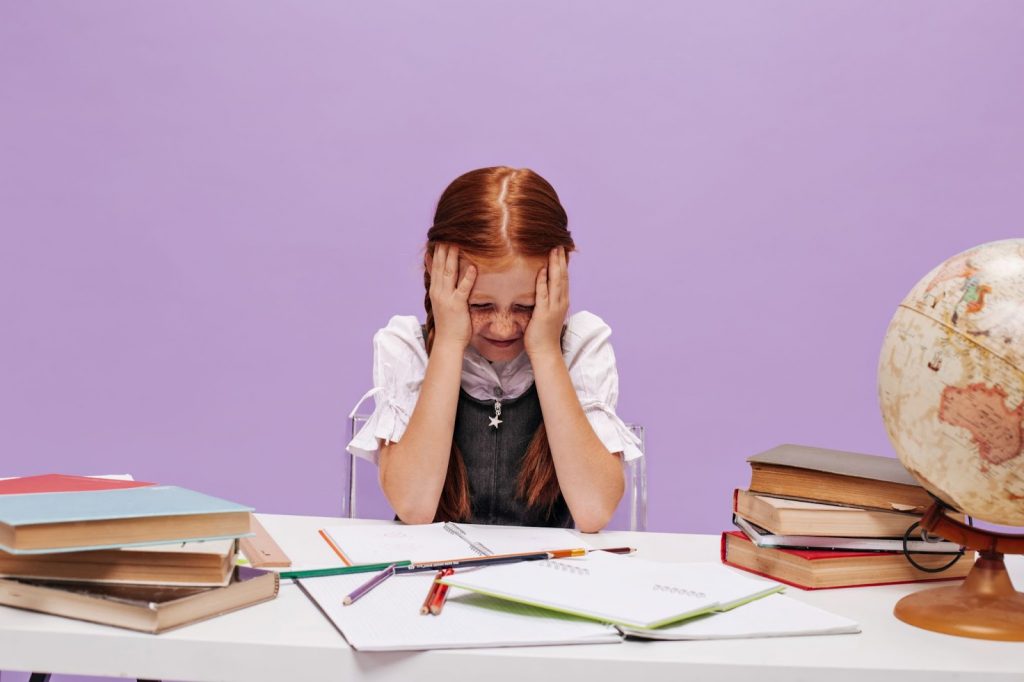 A girl sitting with head on the table