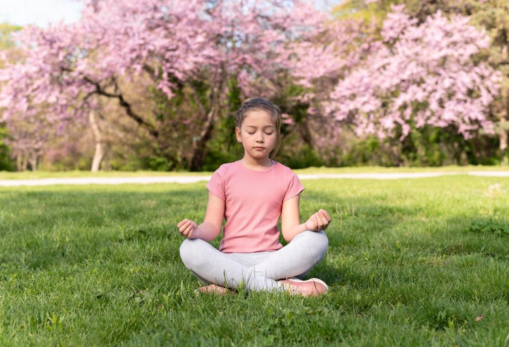 Girl meditating on the grass