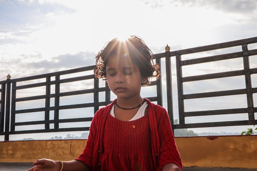 Little girl meditating outdoors