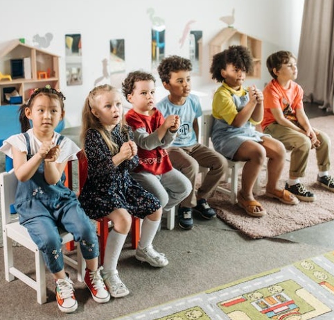 Group of children sitting on classroom chairs