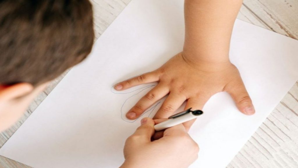 High shot angle of a child tracing the hand of another child