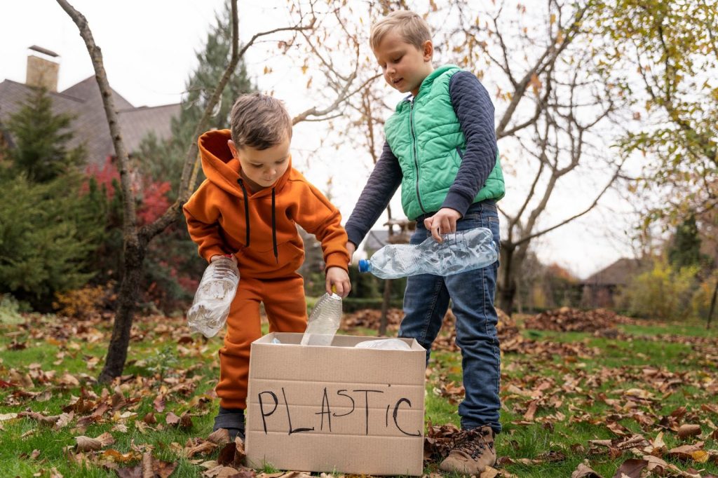 Two kids collecting and putting plastics in a box