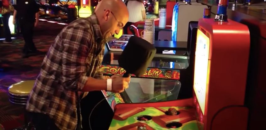 A man playing Whack a Mole game