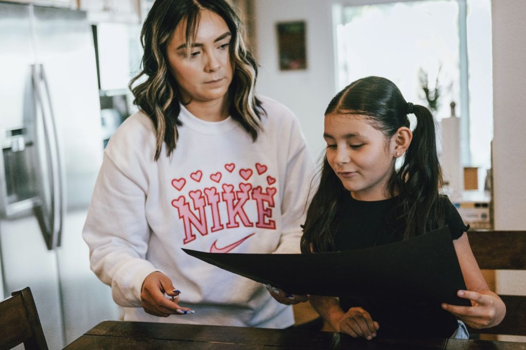 Girl showing her mother a sheet of paper