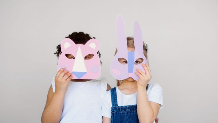 Kids Covering Their Faces With a Cutout Animal Mask