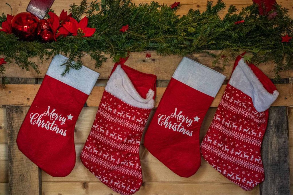 A row of Christmas stockings hung on a wooden wall