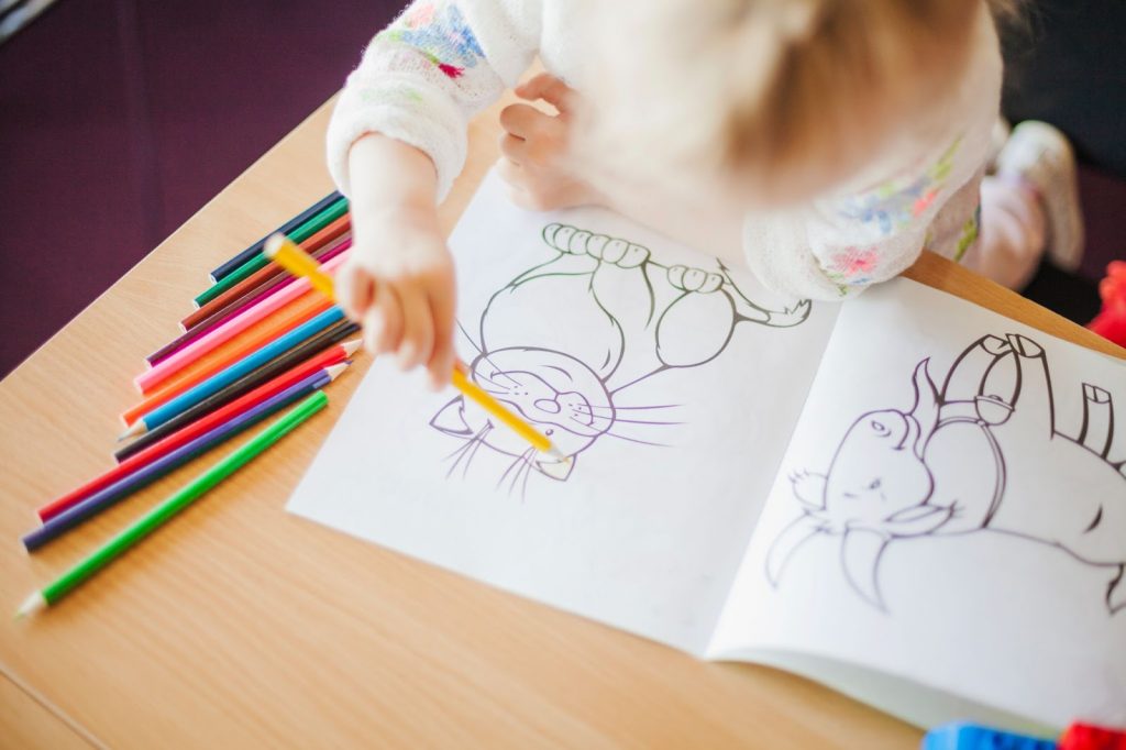 A girl holding coloring pencil