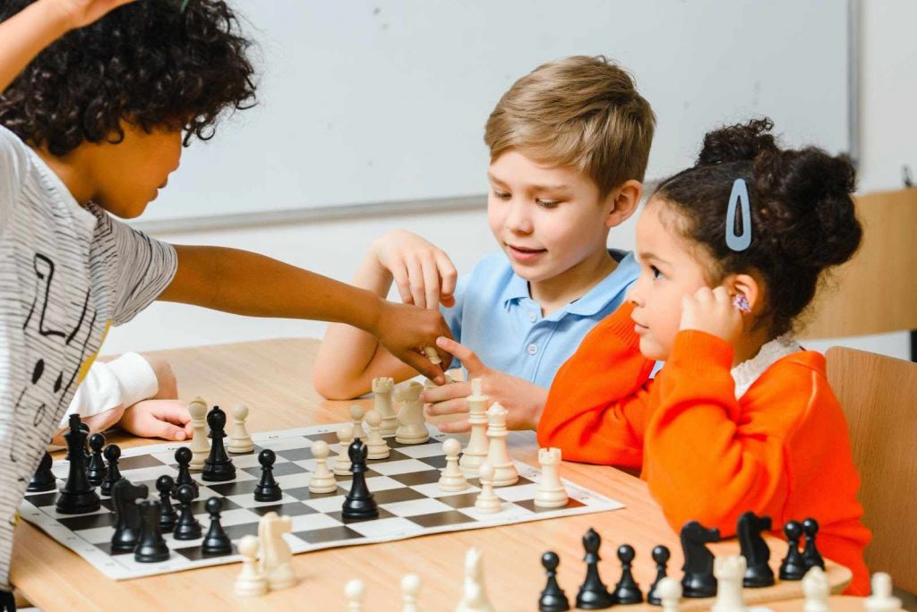 Three children playing chess