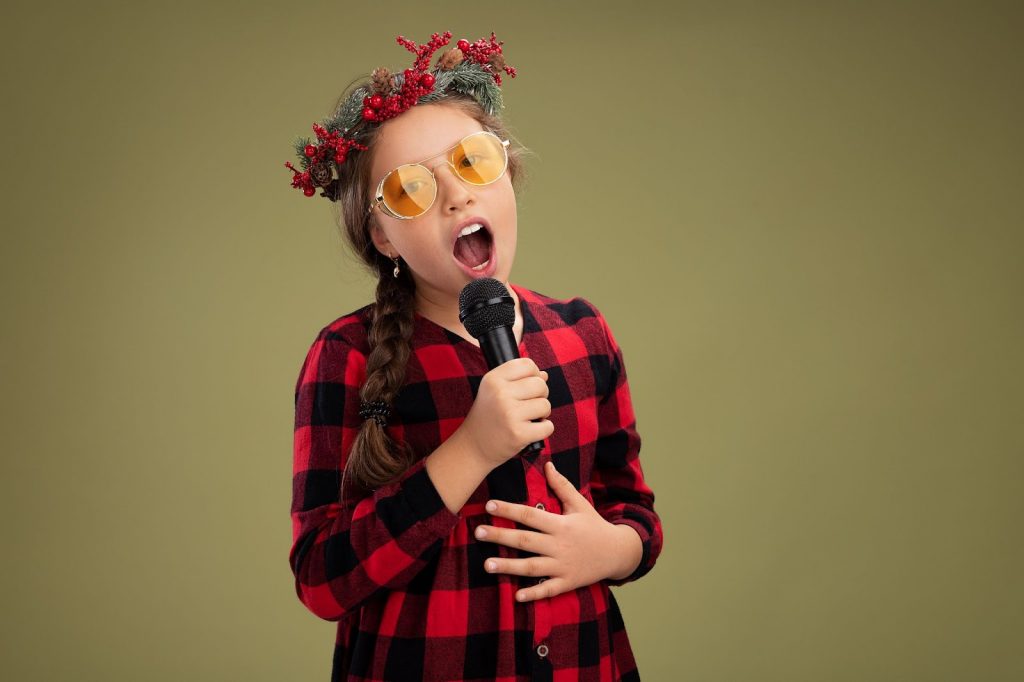 A little girl singing a song with a mic