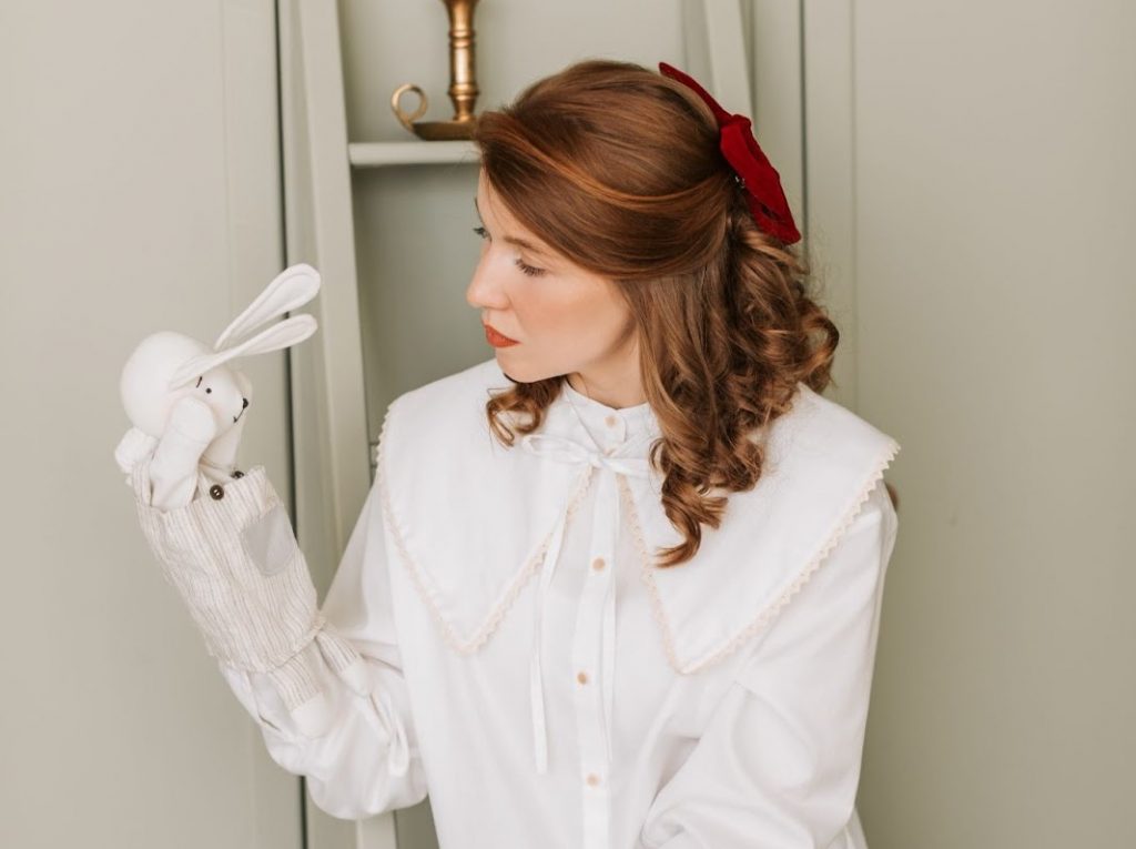 A woman wearing a bunny hand puppet