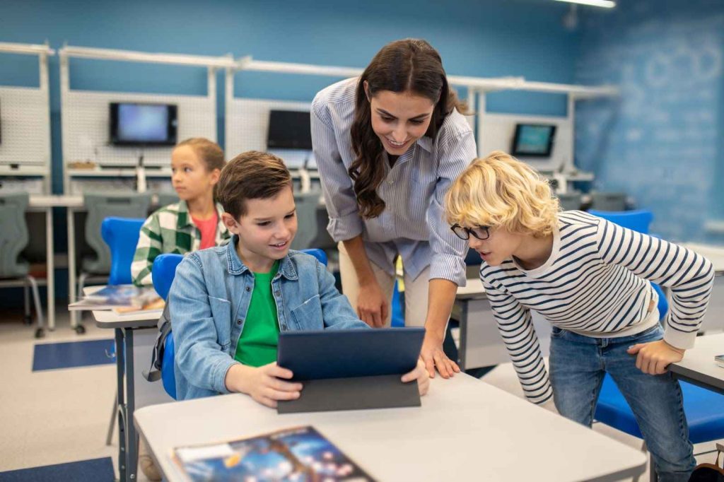 Teacher and kids looking at tablet