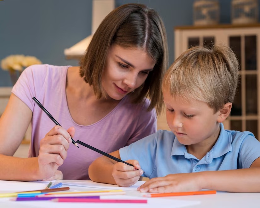 Teacher and student holding pencils engaged in learning activity together