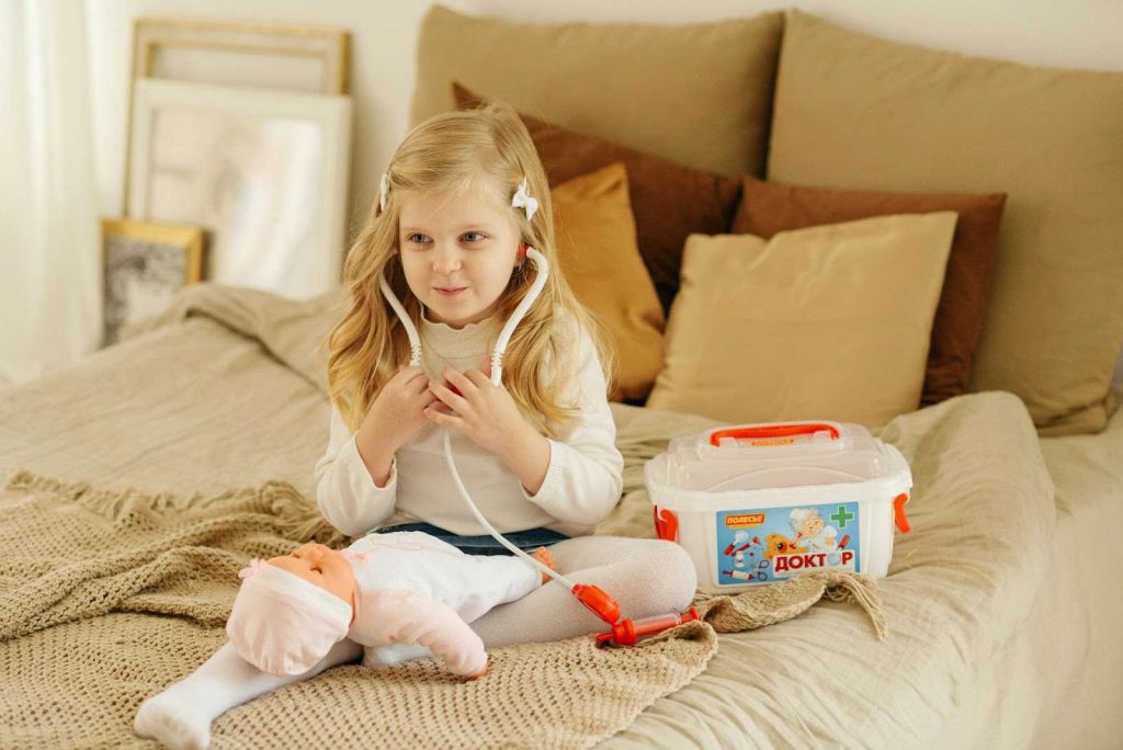 A little girl playing a doctor and treating her doll