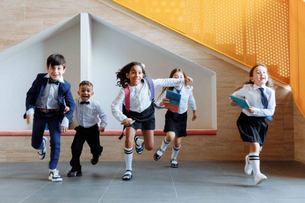 Children running together inside the school