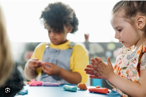 Two girls playing with playdough