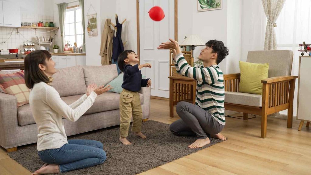 kid playing balloon catch with parents