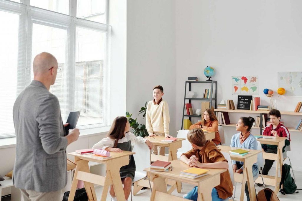 A boy asking a question to all the students in the class