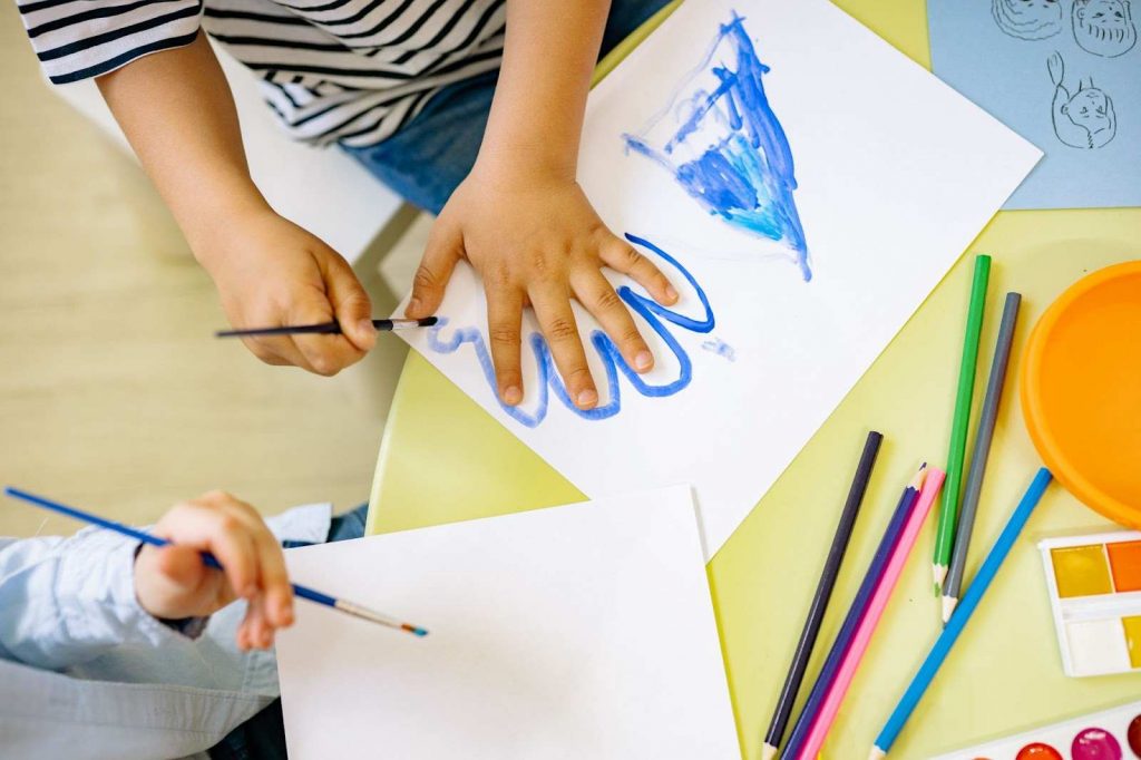 A child tracing his hand on a white sheet of paper