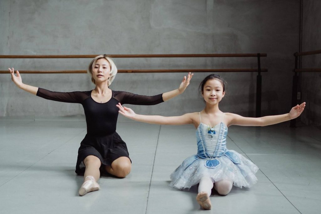 A woman and little girl doing ballet
