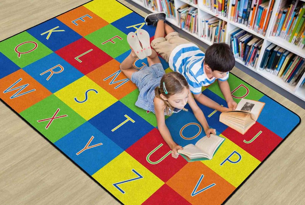 Kids lying on alphabet carpet