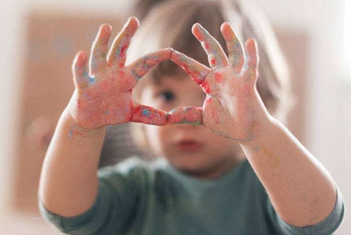 A kid’s hands with paint on it