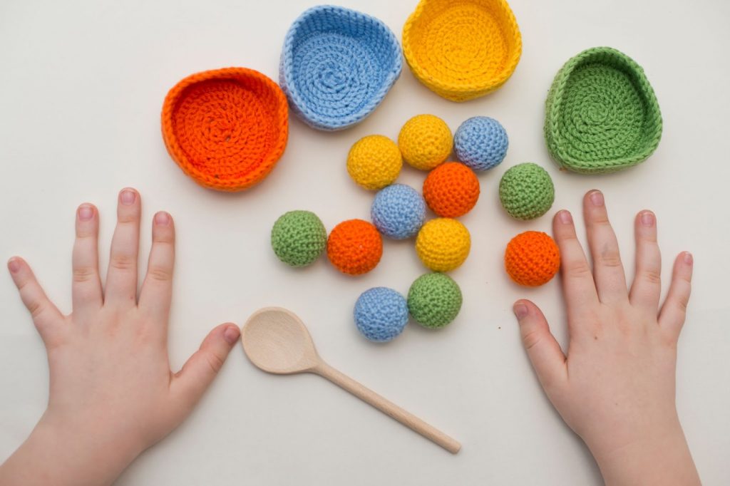 Little knit balls and a kids hand