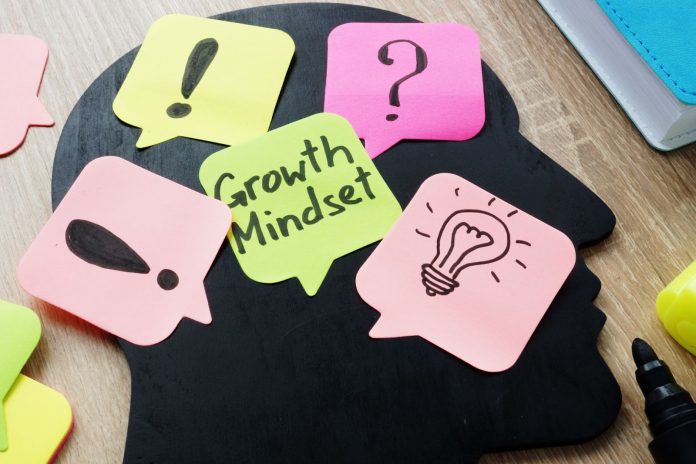 Colorful sheets on table with “growth mindset” written on it