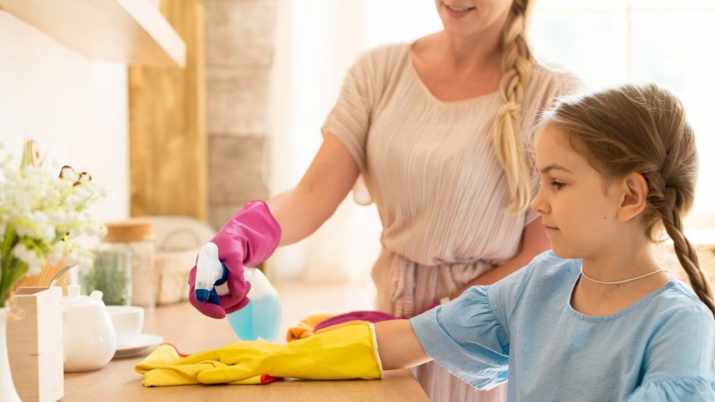 A kid cleaning with her mother