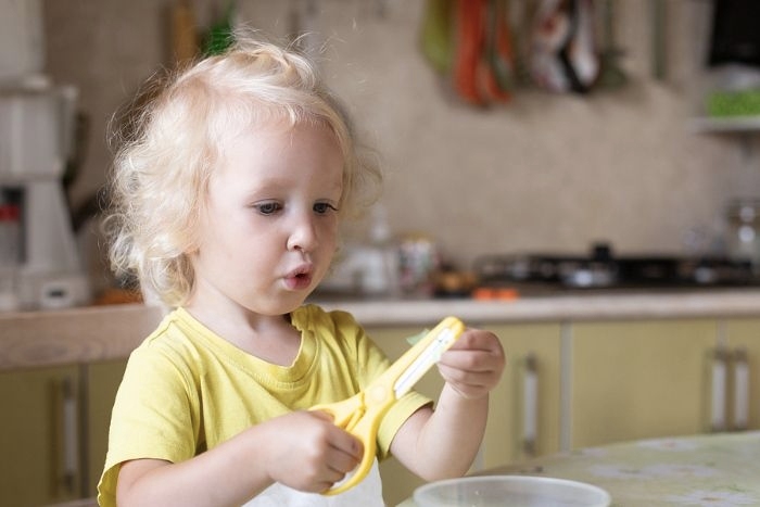 A little child using scissors