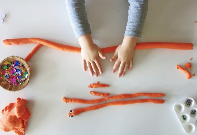 Kid making a snake using playdough