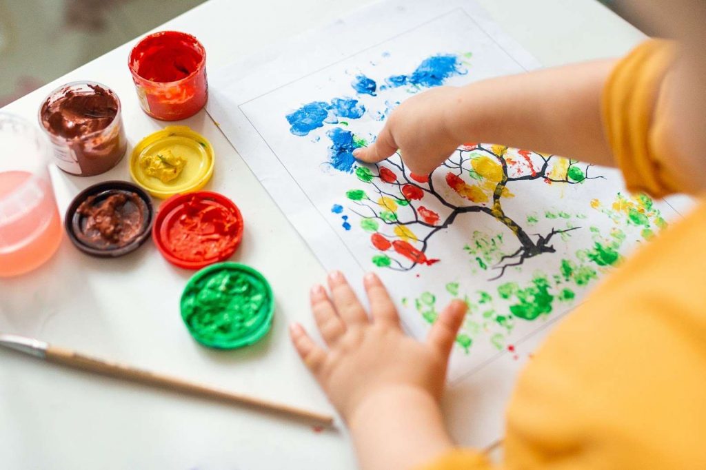 A kid painting with fingers