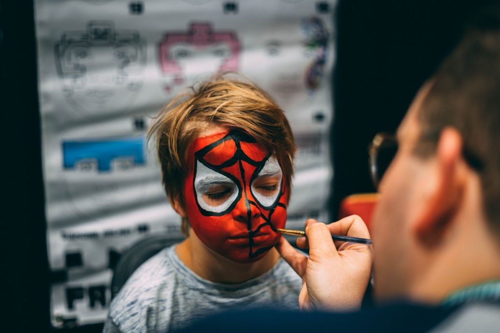 A man painting a boys face